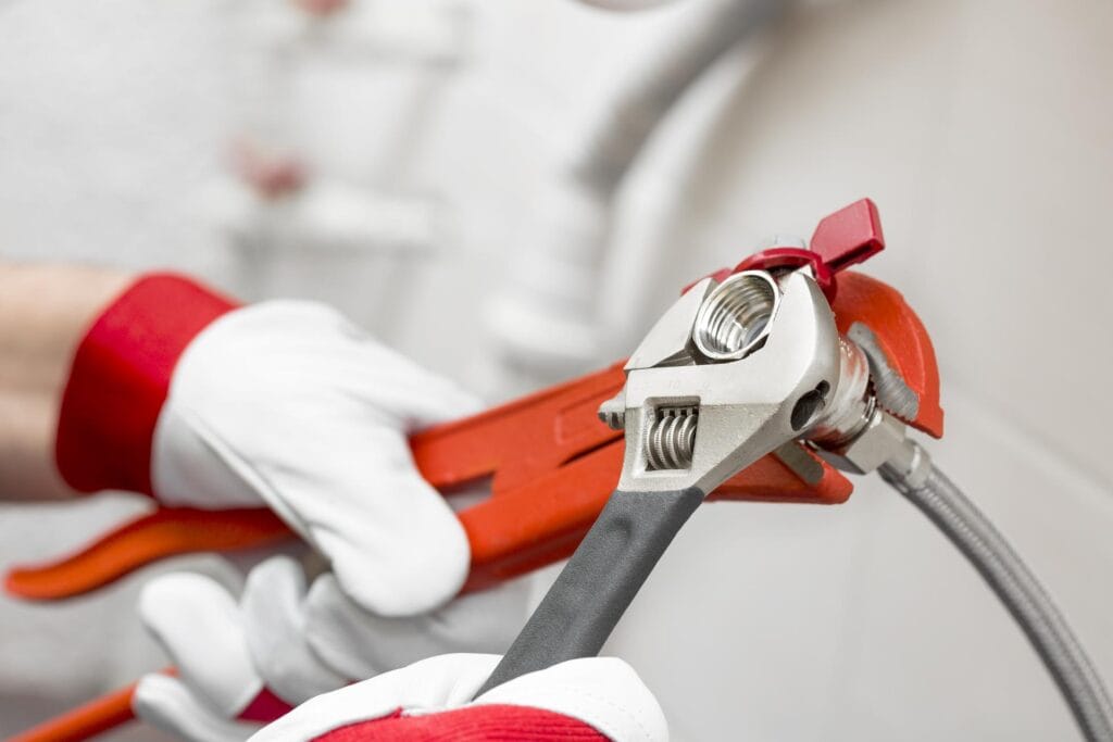 Plumber holding pipe wrenches for an emergency repair in Miami Beach
