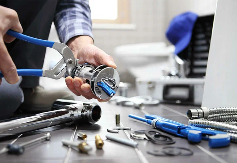 Technician repairing a plumbing fixture with professional tools in Miami Beach