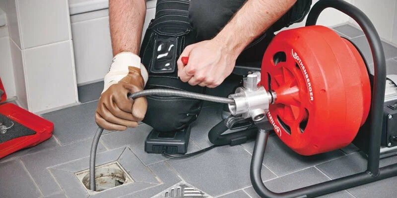 Plumber using a drain-cleaning machine in Miami Beach