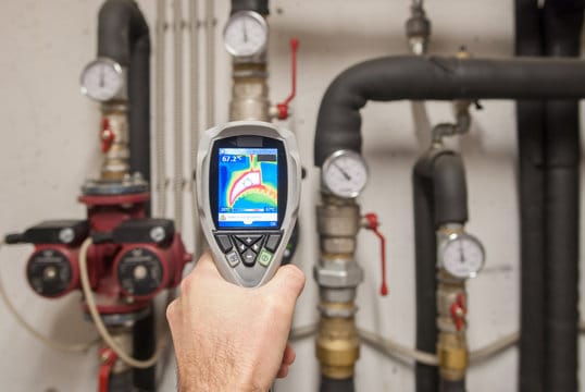Plumber using a thermal imaging camera to inspect pipes in Miami Beach