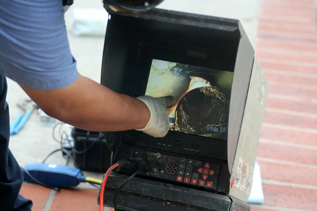 Technician viewing a drain inspection camera in Miami Beach