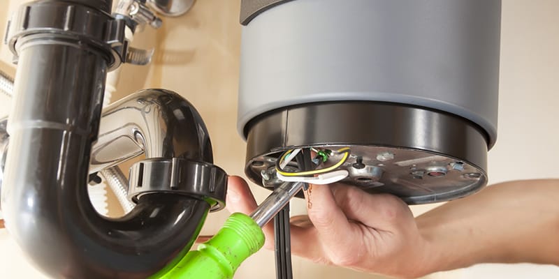 Technician repairing the heating element of a water heater in Miami Beach