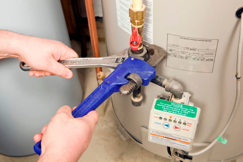 Plumber repairing a water heater valve in Miami Beach